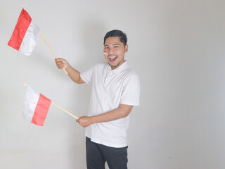 Excited young Asian man celebrate Indonesian independence day on 17 August by holding the...