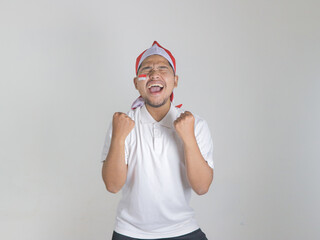 Excited young Asian men celebrate Indonesian independence day on 17 August isolated over white...