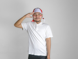 Handsome Asian man giving salute celebrate Indonesian independence day on 17 August isolated over white background