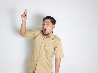 Asian male Indonesian civil servant wearing brown uniform commonly known as keki is standing and...