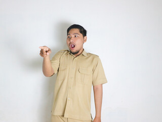 Asian male Indonesian civil servant wearing a brown uniform commonly called keki shows a surprised face while pointing forward. Indonesian civil servants, ASN