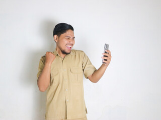 An Asian male Indonesian civil servant wearing a brown uniform, usually called a keki, shows a...
