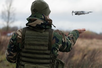 Soldier launching drone in field