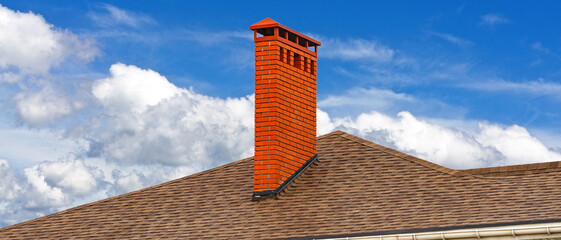 House with a brown asphalt shingle roof and a chimney
