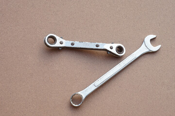 Metal chrome wrenches or spanners  on brown background. Concept, handyman, mechanic tools.  Equipment for fixing or repairing, renovation in daily life.    