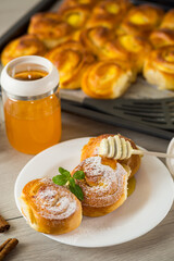 Pastries. Sweet buns with cottage cheese filling and honey in a plate on a wooden table