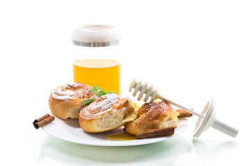Baked goods. Sweet buns with cottage cheese filling and honey in a plate isolated on a white background