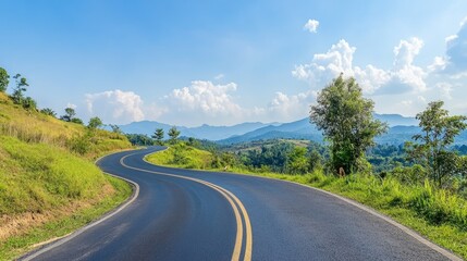 Fototapeta premium Serene Winding Road Through Lush Green Hills with Majestic Mountains Under a Brilliant Blue Sky and Fluffy White Clouds in a Tranquil Landscape