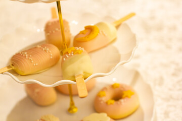 a cake with a gold decoration on it is decorated with pink icing and gold ribbon.