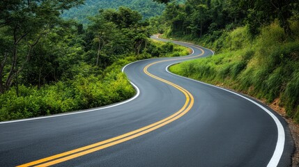 Fototapeta premium Serpentine Road Surrounded by Lush Greenery in a Scenic Landscape Perfect for Travel and Adventure Photography