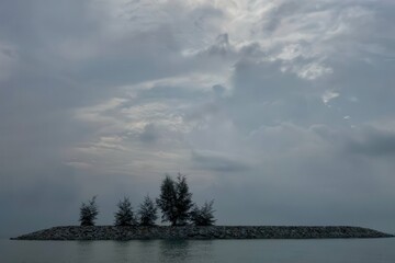 Calm Island Scene with Trees under Cloudy Sky