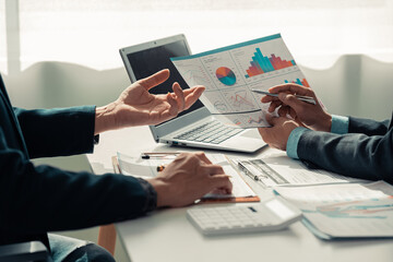 Business people discuss charts and graphs showing successful teamwork in data company growth proposal. Analytical statistics, infographics and strategy ideas