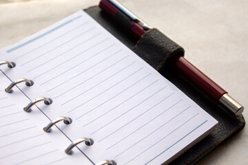close up  of an open daily brown calendar with silver rings isolated on white background. selective focus