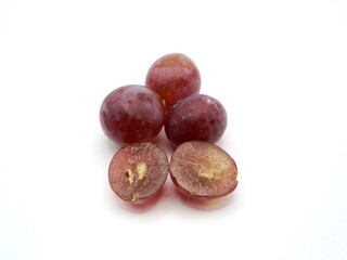 Sweet red grapes on the wooden plate isolated on a white background. Fresh fruit with alot of vitamin C