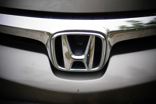 Closeup shot of a silver Honda logo on a car