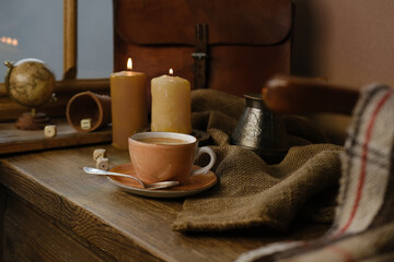 cup with drink coffee on old vintage wooden table, metal coffee maker, candles burn, caffeine improves functioning of human brain, stimulates nervous system, health benefits and harms, copy space