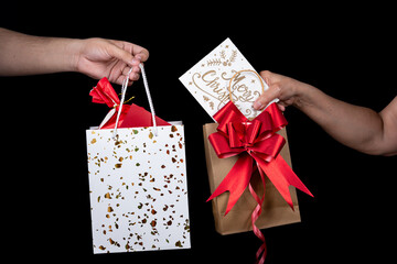 Hands Exchanging Christmas Gifts with Festive Wrapping and Card