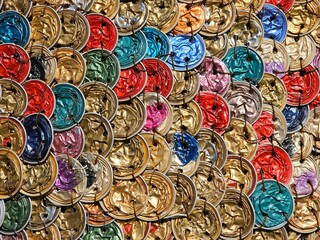 Colorful crushed coffee capsules (or coffee pods), recycled and arranged in a textured pattern