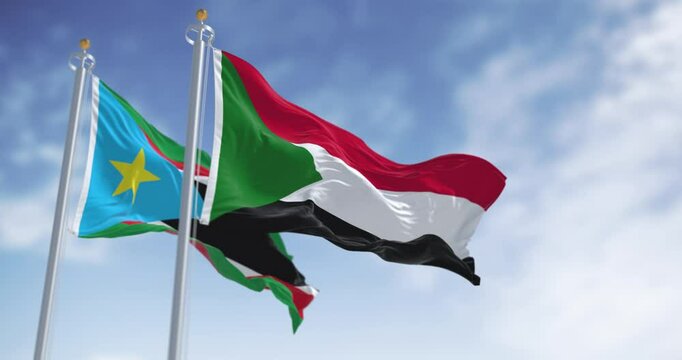 Sudan and South Sudan national flags waving in the wind on a clear day