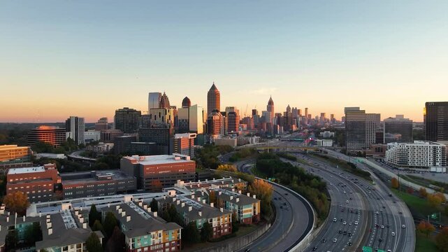 Drone footage of highways and buildings in Atlanta near Atlantic Station shot in 4k. Sideways pan of skyline in Atlanta at sunset. Close up shot o the buildings with sun reflection on buildings. 
