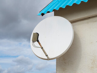 Satellite internet and TV signal receiver antenna on the house wall