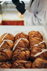 A box of freshly baked sweet croissants with fillings, close-up.