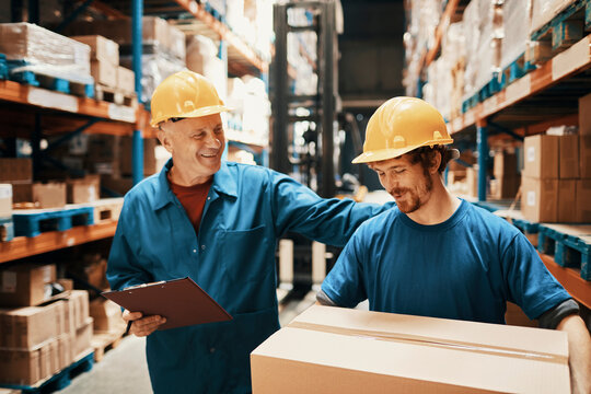 Supervisor and warehouse worker discussing logistics while checking inventory
