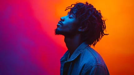Fototapete Man with dreadlocks is wearing a blue jacket and looking at the camera. The image has a vibrant and colorful feel to it, with the man's outfit © Trusha