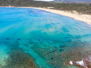 Aerial view of a sandy beach with turquoise water in Sardinia