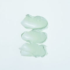 Light green blob of lotion with a soft on a plain white background