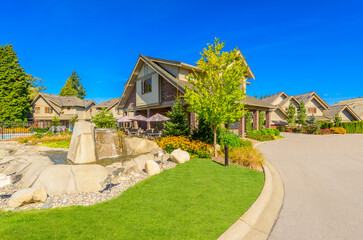 Neighbourhood of luxury houses in summer with street road, big trees and nice landscape in Vancouver, Canada. Blue sky. Day time on August 2024.