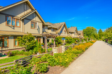 Neighbourhood of luxury houses in summer with street road, big trees and nice landscape in Vancouver, Canada. Blue sky. Day time on August 2024.