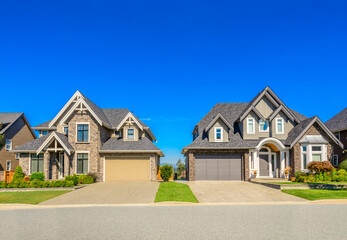 Neighbourhood of luxury houses in summer with street road, big trees and nice landscape in Vancouver, Canada. Blue sky. Day time on August 2024.
