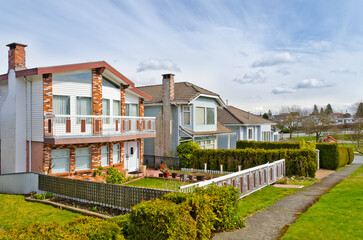 Neighbourhood of luxury houses in summer with street road, big trees and nice landscape in Vancouver, Canada. Blue sky. Day time on August 2024.