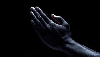 Fototapeta premium Dark dramatic composition of hands in prayer muted lighting evoking deep emotion and spiritual reflection
