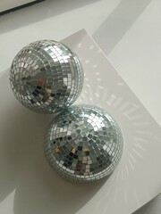 Two Disco Balls on a Table with Sunlight and Reflection
