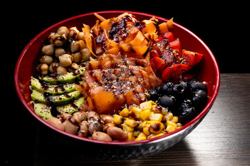Salad with avocado, corn, olives, beans carrots, tomato,  chickpeas, sauce.