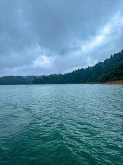 Expansive kenyir Lake with Distant Forested Mountains Under Overcast Skies