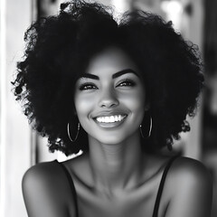 beautiful black woman smiling with curly hair in black and white. Her joyful expression radiates warmth and confidence, capturing moment of happiness