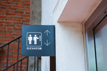 Elevator sign at  first floor of vintage shopping mall. Close up of Lift (elevator) sign on black wall background.
