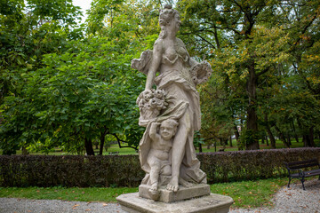 Statue of Flora (goddess of flowers and spring) with putti in park. Będzin, Poland.