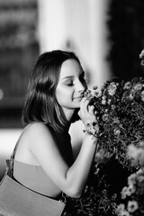 Portrait of a young beautiful dark-haired girl in the park. Black and white photo.