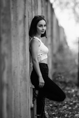 Portrait of a young beautiful dark-haired girl in the park. Black and white photo.