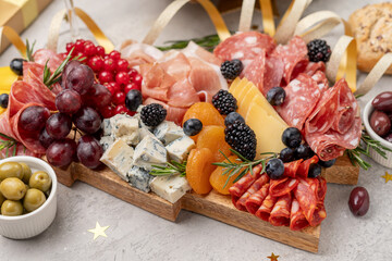 Party charcuterie board italian food antipasti prosciutto ham, salami and cheese appetizers served in the shape of a Christmas tree. party food for New Year's Eve, Christmas or birthday