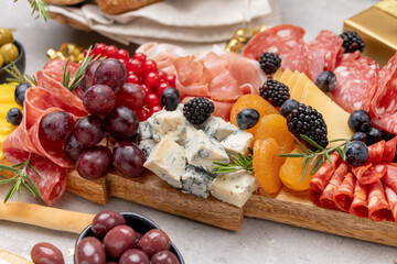 Party charcuterie board italian food antipasti prosciutto ham, salami and cheese appetizers served in the shape of a Christmas tree. party food for New Year's Eve, Christmas or birthday