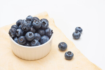 Fresh blueberries in a bowl on a light background. Harvesting
