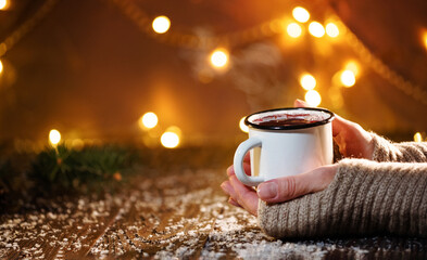 Close-up of traditional Christmas mulled wine with spices. Female hands with mulled wine at the...