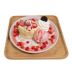 A delicious dessert featuring fluffy pancakes topped with strawberries, whipped cream, and a scoop of ice cream, garnished with raspberries and an Oreo.