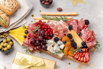 Party charcuterie board italian food antipasti prosciutto ham, salami and cheese appetizers served in the shape of a Christmas tree. party food for New Year's Eve, Christmas or birthday
