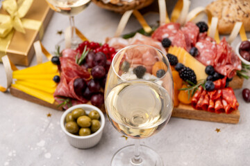 Glass of champagne, Prosecco or white  wine , festive aperitif or party food and drink with cold meat appetizers cheeses and olives , party food for New Year's Eve, Christmas or birthday